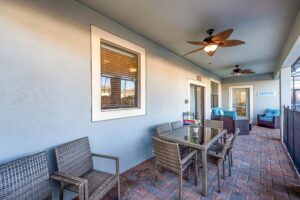 Champions Gate Epic Villa covered patio with dining table, chairs and patio furniture seating