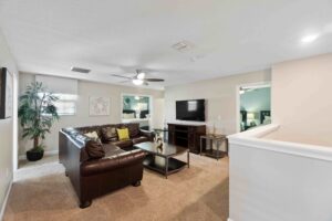 Champions Gate Rolling Skies upstairs loft living room with sectional couch and big screen smart tv