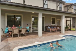 Guests dining and relaxing on the covered patio beside the pool at Rolling Skies