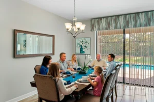 Family dining beside the pool-facing doors at Rolling Skies